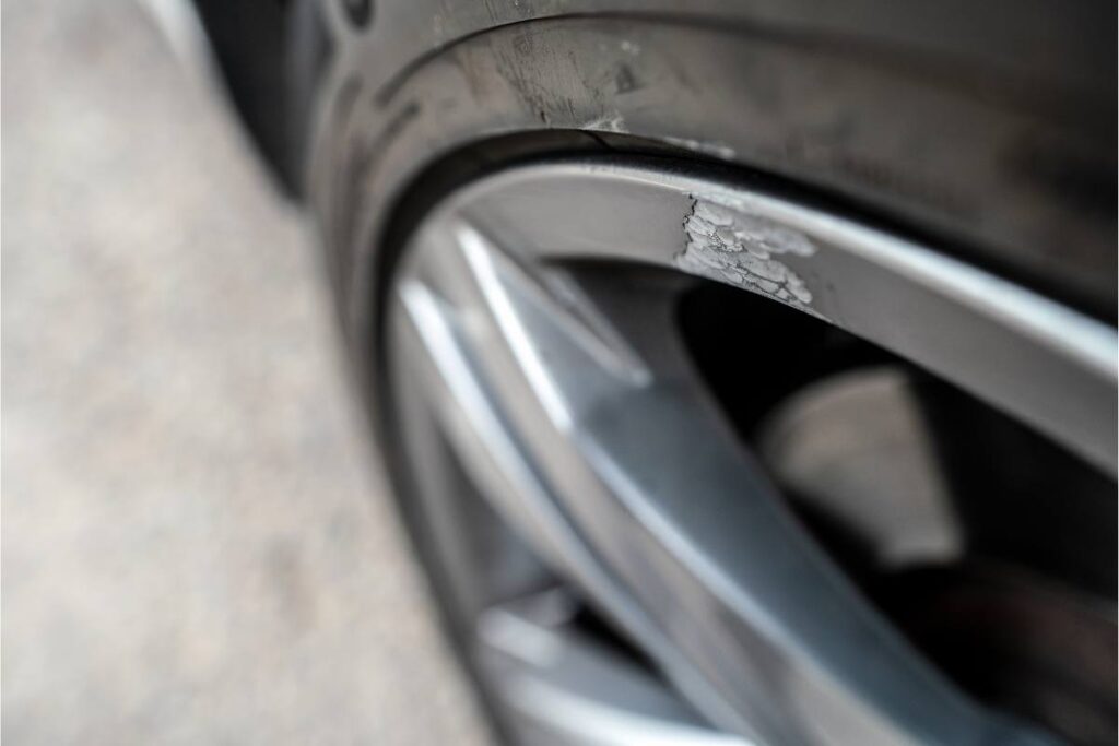 Close-up of a car rim showing signs of scraping and damage.